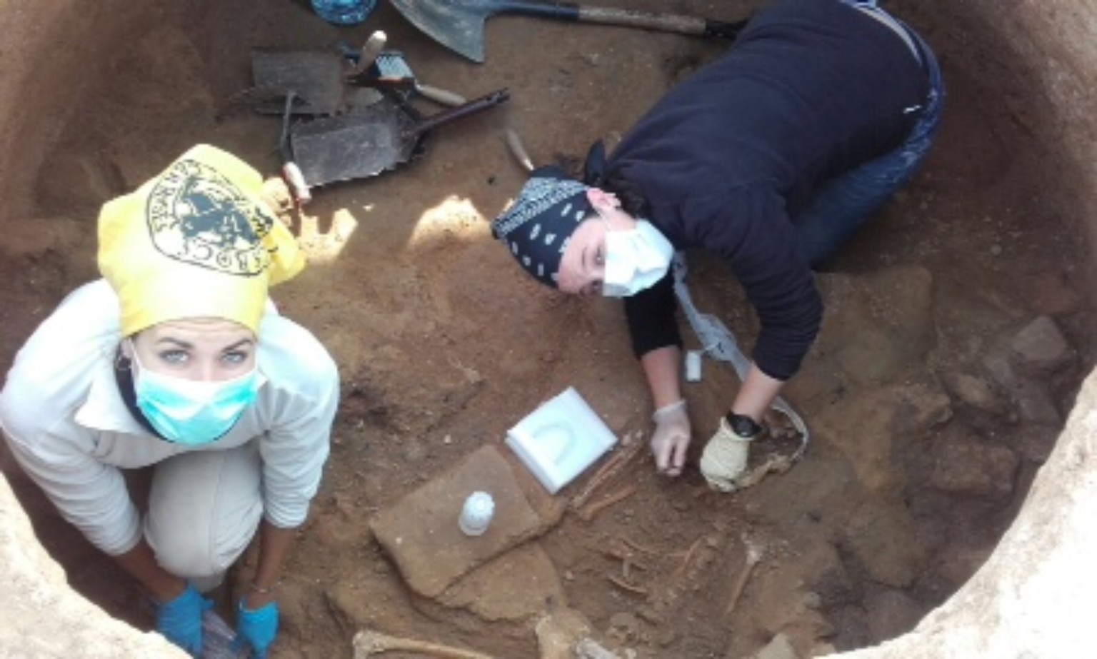 Treballs d’excavació de les restes humanes, amb guants i mascaretes.