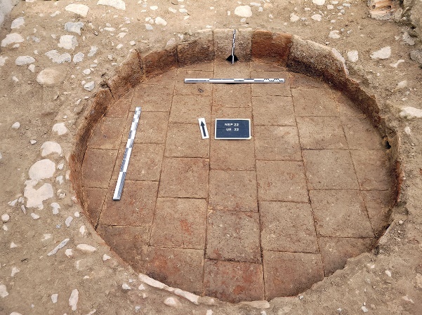 Cup circular del celler de Sant Pere de Riudebitlles amb el fons de rajoles de ceràmica conservat i escales arqueològiques